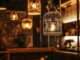 Warm verlichte horecazaak met decoratieve hanglampen boven tafels