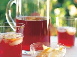 Glazen kan en glazen met rode alcoholvrije ijsthee en citrusfruit