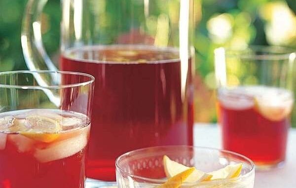 Glazen kan en glazen met rode alcoholvrije ijsthee en citrusfruit